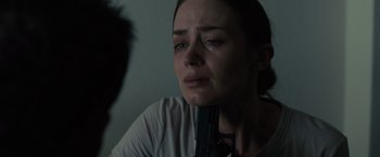 Movie still from “Sicario” (2015), directed by Denis Villeneuve – A woman holding a gun in her hand and crying; Close Up shot, Over the shoulder angle