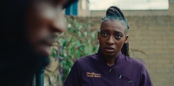 Movie still from “Top Boy” (2011), created by Ronan Bennett – A woman in a purple jacket looking at a man in a purple jacket; Close Up shot, Over the shoulder angle