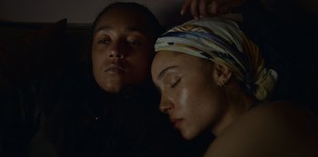 Movie still from “Top Boy” (2011), created by Ronan Bennett – Two people sleeping on a bed with one of them wearing a headscarf; Close Up shot, High angle