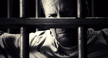 Movie still from “Sin City” (2005), directed by Frank Miller – A black and white photo of a man behind bars; Extreme Close Up shot, High angle