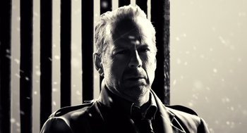 Movie still from “Sin City” (2005), directed by Frank Miller – Black and white photograph of a man in a suit and tie; Close Up shot, Low angle