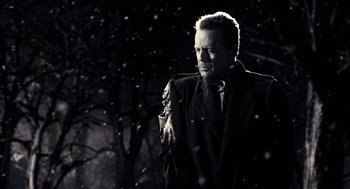 Movie still from “Sin City” (2005), directed by Frank Miller – A black and white photo of a man in the snow; Close Up shot, Low angle
