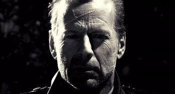 Movie still from “Sin City” (2005), directed by Frank Miller – Black and white photograph of a man's face; Close Up shot, Low angle