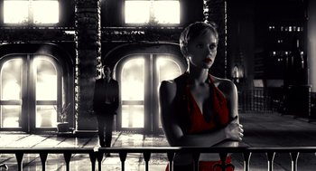 Movie still from “Sin City” (2005), directed by Frank Miller – A black and white photo of a woman in a red dress; Medium shot, Low angle