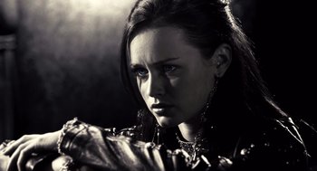 Movie still from “Sin City” (2005), directed by Frank Miller – A woman with blue eyes is looking at the camera; Close Up shot, Over the shoulder angle