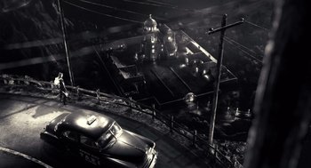 Movie still from “Sin City” (2005), directed by Frank Miller – An aerial view of an old time town at night; Extreme Wide shot, High angle