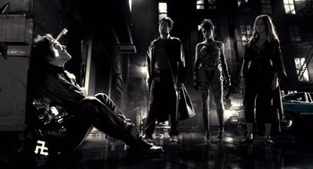Movie still from “Sin City” (2005), directed by Frank Miller – A group of people standing next to each other in a room; Wide shot, Low angle