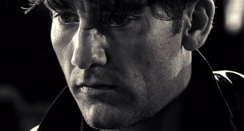 Movie still from “Sin City” (2005), directed by Frank Miller – Black and white photograph of a man's face; Extreme Close Up shot, Low angle