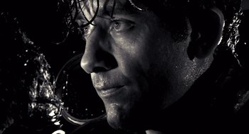Movie still from “Sin City” (2005), directed by Frank Miller – Black and white close up of a man's face; Extreme Close Up shot, Low angle