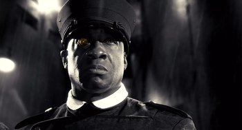 Movie still from “Sin City” (2005), directed by Frank Miller – A black and white photo of a man wearing a uniform; Close Up shot, Low angle