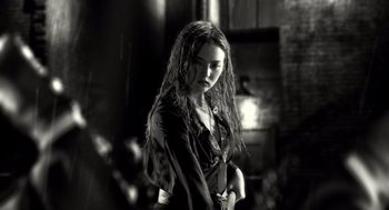 Movie still from “Sin City” (2005), directed by Frank Miller – A woman with long hair and a black shirt; Medium shot, Low angle