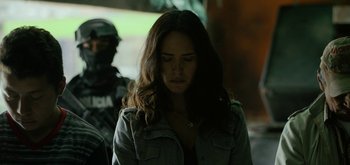 Movie still from “Triple Frontier” (2019), directed by J.C. Chandor – A woman is standing in front of a police officer; Close Up shot, Low angle