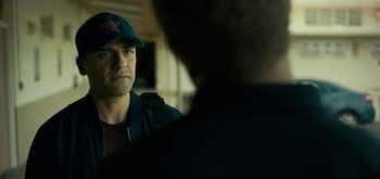Movie still from “Triple Frontier” (2019), directed by J.C. Chandor – A man wearing a baseball cap looking into a mirror; Close Up shot, Over the shoulder angle