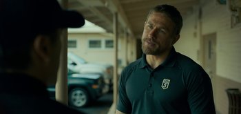 Movie still from “Triple Frontier” (2019), directed by J.C. Chandor – A person wearing a polo shirt; Close Up shot, Over the shoulder angle