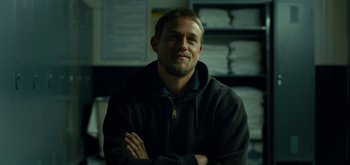 Movie still from “Triple Frontier” (2019), directed by J.C. Chandor – A person with his arms crossed; Close Up shot, Low angle