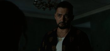 Movie still from “Triple Frontier” (2019), directed by J.C. Chandor – A person with a necklace; Close Up shot, Over the shoulder angle