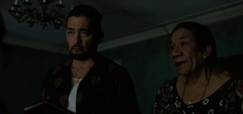 Movie still from “Triple Frontier” (2019), directed by J.C. Chandor – A man and a woman standing next to each other in a room; Medium shot, Over the shoulder angle