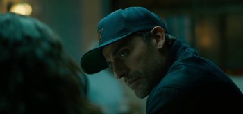 Movie still from “Triple Frontier” (2019), directed by J.C. Chandor – A person wearing a hat; Close Up shot, Over the shoulder angle