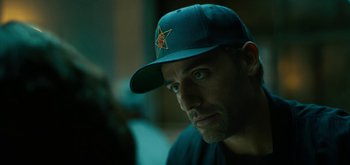 Movie still from “Triple Frontier” (2019), directed by J.C. Chandor – A person wearing a hat; Close Up shot, Over the shoulder angle