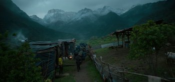 Movie still from “Triple Frontier” (2019), directed by J.C. Chandor – A group of people walking down a dirt road; Extreme Wide shot, High angle