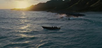 Movie still from “Triple Frontier” (2019), directed by J.C. Chandor – Two people in a boat in the ocean at sunset; Extreme Wide shot, High angle