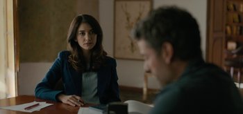 Movie still from “Triple Frontier” (2019), directed by J.C. Chandor – A woman sitting in front of a man at a table; Medium shot, Over the shoulder angle