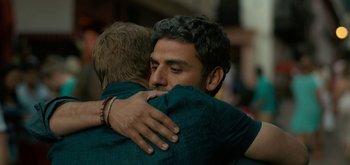 Movie still from “Triple Frontier” (2019), directed by J.C. Chandor – Two men hugging each other in the middle of the street; Close Up shot, Over the shoulder angle