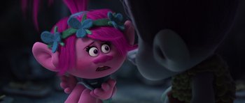 Movie still from “Trolls” (2016), directed by Mike Mitchell – A pink haired troll is looking at a person; Close Up shot, Over the shoulder angle