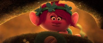 Movie still from “Trolls” (2016), directed by Mike Mitchell – A red haired girl with a flower crown is looking at the camera; Close Up shot, Over the shoulder angle