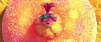 Movie still from “Trolls” (2016), directed by Mike Mitchell – A troll doll on a bed of sprinkles; Medium shot, Overhead angle