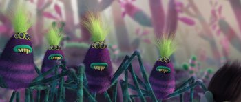 Movie still from “Trolls” (2016), directed by Mike Mitchell – A couple of purple stuffed animals with green hair; Medium shot, Over the shoulder angle