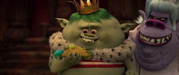 Movie still from “Trolls” (2016), directed by Mike Mitchell – A troll with a crown eating a taco; Close Up shot, High angle