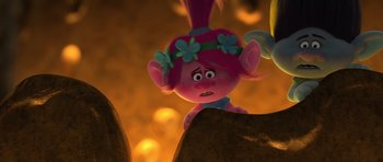 Movie still from “Trolls” (2016), directed by Mike Mitchell – A pink troll with flowers on her head; Close Up shot, Over the shoulder angle