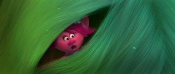 Movie still from “Trolls” (2016), directed by Mike Mitchell – A pink troll is peeking out from behind a green leaf; Close Up shot, Over the shoulder angle