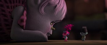 Movie still from “Trolls” (2016), directed by Mike Mitchell – A troll looking at a troll doll in a dark room; Medium shot, Over the shoulder angle