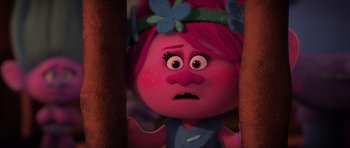 Movie still from “Trolls” (2016), directed by Mike Mitchell – A pink troll is looking at the camera; Close Up shot, Over the shoulder angle