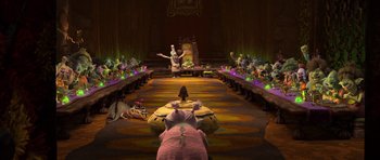 Movie still from “Trolls” (2016), directed by Mike Mitchell – A group of people sitting in a room with a table; Wide shot, High angle