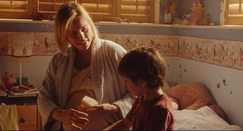 Movie still from “Tully” (2018), directed by Jason Reitman – A woman and a boy are playing with a toy; Medium shot, Over the shoulder angle