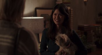 Movie still from “Tully” (2018), directed by Jason Reitman – A woman holding a small dog in her arms; Medium shot, Over the shoulder angle