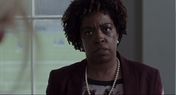 Movie still from “Tully” (2018), directed by Jason Reitman – A person wearing a suit and pearls; Close Up shot, Over the shoulder angle