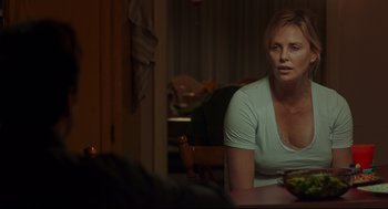 Movie still from “Tully” (2018), directed by Jason Reitman – Charlize theron sitting at a table in front of a mirror; Medium shot, Over the shoulder angle