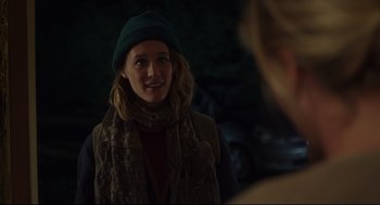 Movie still from “Tully” (2018), directed by Jason Reitman – A woman wearing a green hat and a scarf smiling; Close Up shot, Over the shoulder angle