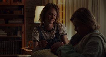 Movie still from “Tully” (2018), directed by Jason Reitman – A woman is holding a baby in her arms; Medium shot, Over the shoulder angle