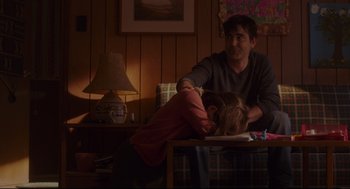 Movie still from “Tully” (2018), directed by Jason Reitman – A man and a woman sitting at a table in front of a lamp; Medium shot, Over the shoulder angle