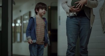 Movie still from “Tully” (2018), directed by Jason Reitman – A young boy standing next to an older woman; Medium shot, Over the shoulder angle