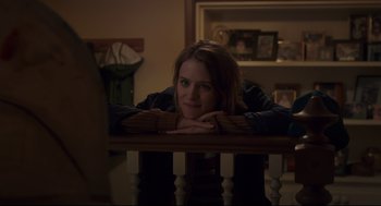Movie still from “Tully” (2018), directed by Jason Reitman – A woman leaning on a railing in a living room; Medium shot, Over the shoulder angle