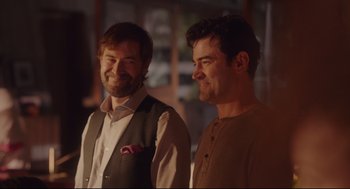 Movie still from “Tully” (2018), directed by Jason Reitman – A couple of men standing next to each other; Medium shot, Over the shoulder angle