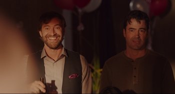 Movie still from “Tully” (2018), directed by Jason Reitman – Two men standing next to each other at a party; Medium shot, Over the shoulder angle