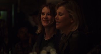 Movie still from “Tully” (2018), directed by Jason Reitman – Two women smile for the camera at a party; Close Up shot, Over the shoulder angle