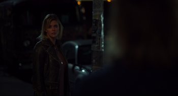 Movie still from “Tully” (2018), directed by Jason Reitman – A woman standing in the dark looking at the camera; Close Up shot, Over the shoulder angle